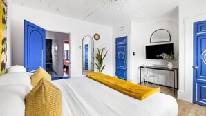 Een moderne slaapkamer met een groot bed, een bureau en een televisie.