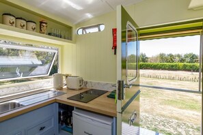Une cuisine compacte avec une fenêtre, un grille-pain, une bouilloire et des boîtes de rangement.