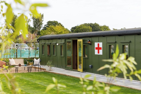 Experience a piece of history in our beautifully restored WW2 ambulance train carriage. Relax in the serene outdoor seating area with lush green surroundings.