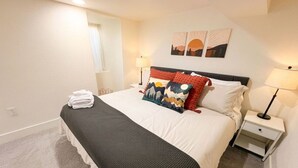 A neatly arranged hotel room with a bed, bedside tables, and a window. - Spacious 2BR Garden Suite in Denver Highlands (Denver)