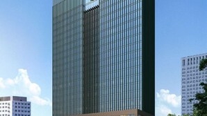 Un bâtiment moderne et imposant, doté d’une façade à motifs géométriques et d’un logo bien visible sur le dessus.