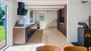 Eine moderne Küche mit Holzschränken, einem Einbauofen und einem großen Fenster.