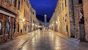 A historic street with stone buildings, a central tower, and a paved walkway. - Dubrovnik Cozy central Studio with street View (Dubrovnik)