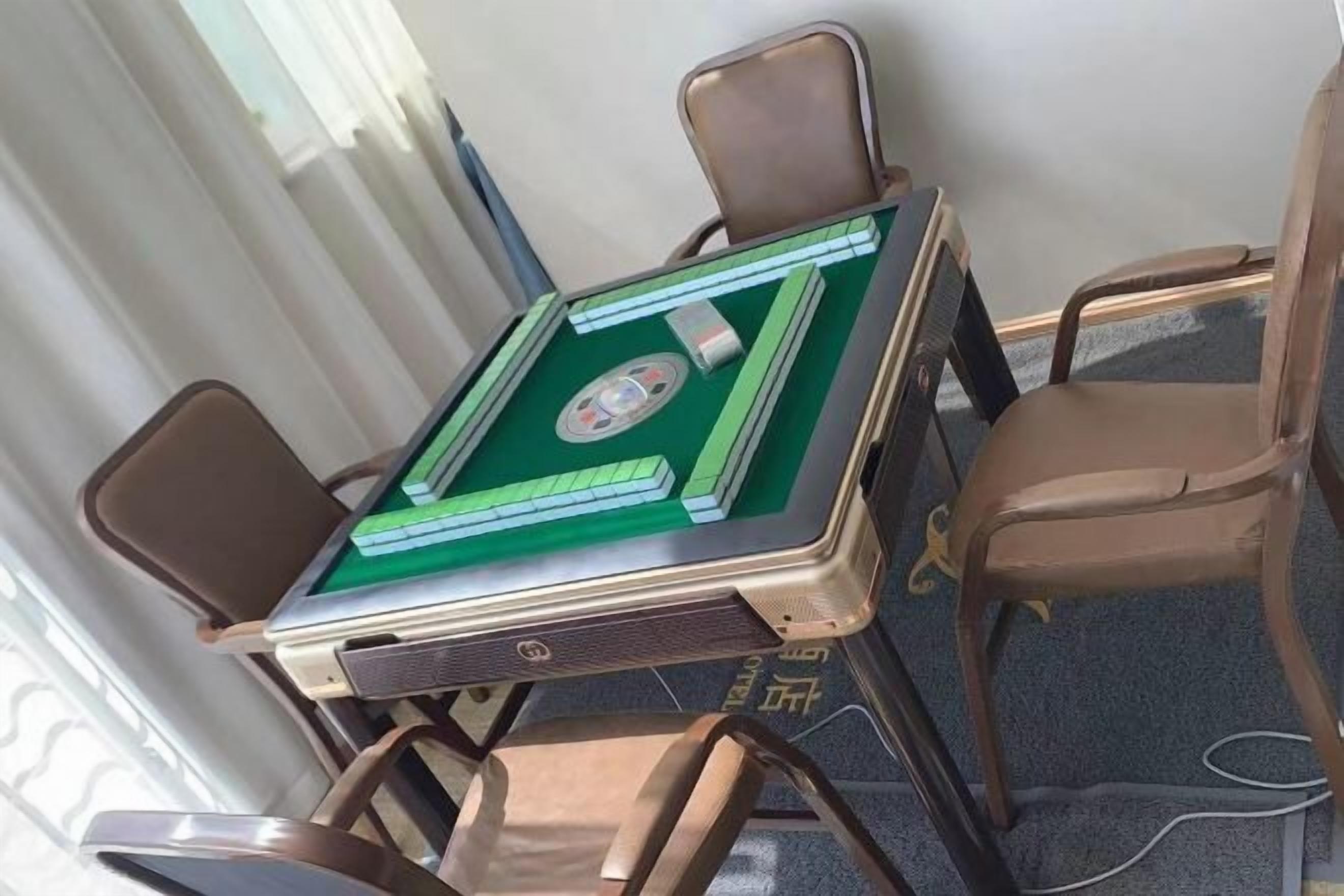 Una habitación con mesa de billar, cuatro sillas y una ventana con cortinas.