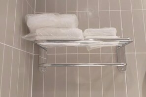 A bathroom with a towel rack holding several white towels. - Jinjiang (Zhuhai Xiangzhou Qinglv Middle Road Grand Theatre) (Zhuhai)
