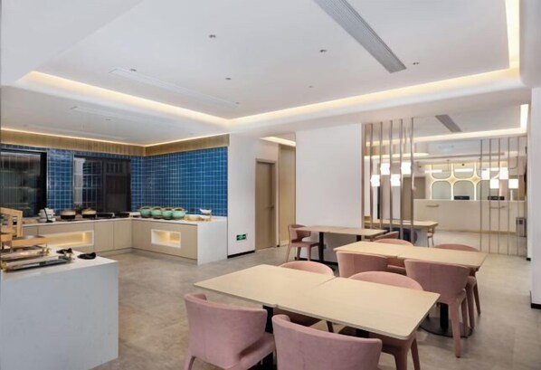 A modern hotel room with a kitchen area, a dining area with pink chairs, and a large window. - Jinjiang (Zhuhai Xiangzhou Qinglv Middle Road Grand Theatre) (Zhuhai)
