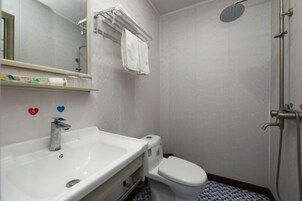 Un baño con lavamanos, inodoro y ducha.