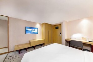 A hotel room with a bed, a desk, a chair, a bench, a wardrobe, and a TV screen displaying information. - Lavande Hotels(Shenzhen Fanshen Metro Station&Wanda Plaza ) (Shenzhen)