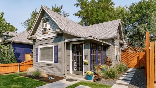 A two-story house with a grey roof, a front porch, and a small garden with stepping stones leading to the door. - #StayinMyDistrict Hyde Park Northend Studio (Boise)