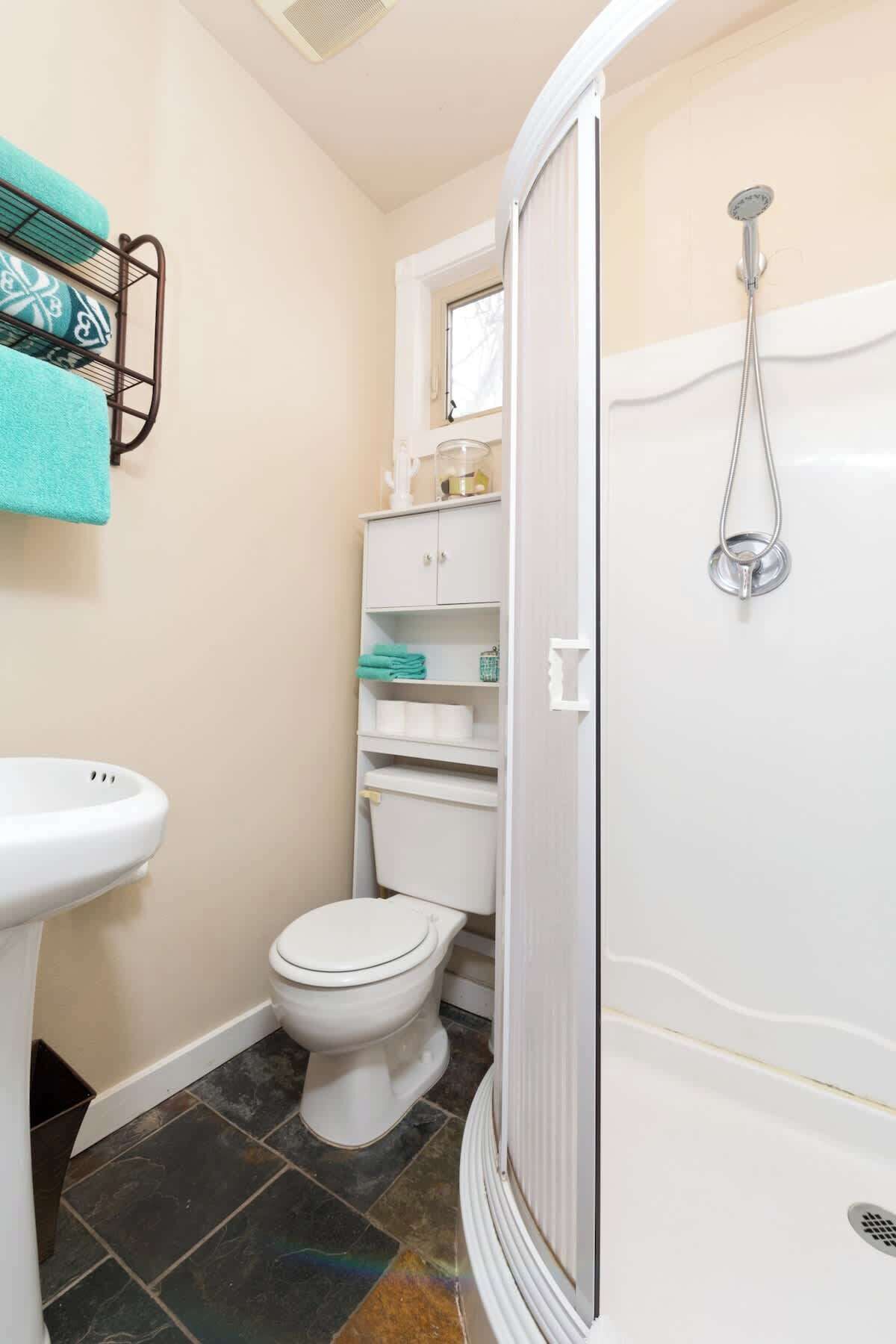 Un baño pequeño con inodoro, lavamanos y ducha.
