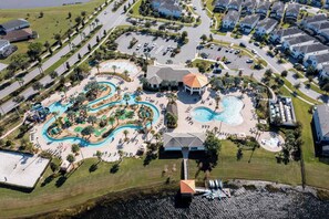 An aerial view of a resort with multiple swimming pools, a water park, and a clubhouse. - Stylish 2-BR Apt, Sleeps 7, Near Disney Magic (Kissimmee)