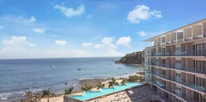 Enjoy ocean views from the comfort of your balcony, with the beach and pool just steps away.