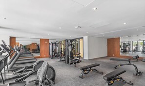 A gym with treadmills, weight machines, and benches.