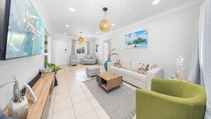 A modern living room with a sofa, coffee table, and a TV mounted on the wall.