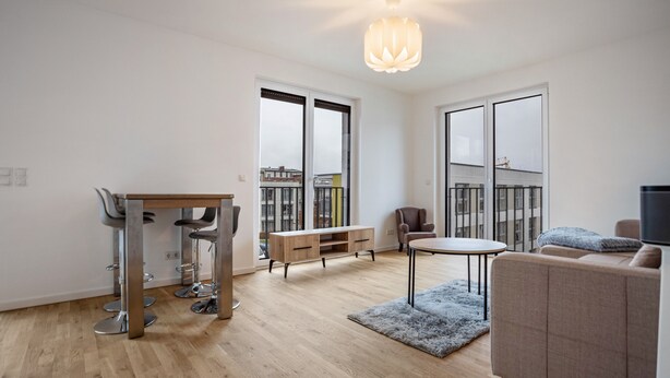 A modern living room with a dining area, a sofa, a TV, and a view of the city through large windows.