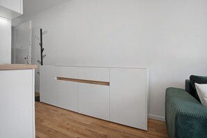 A minimalist room with a bed, a wooden floor, and a white wardrobe. - Apartment 'Modernes Und Wundervolles Loft' with Wi-Fi (Greifswald)