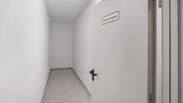 A hallway with a door labeled 'Kinderwagen' and a black handle.