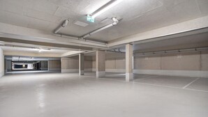 Een lege parkeergarage met betonnen pilaren en een nette, onversierde vloer.