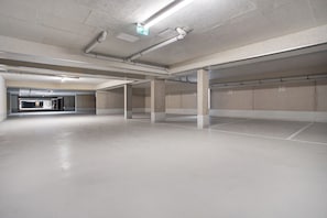 An empty parking garage with concrete pillars and a clean, unadorned floor. - Apartment 'Modernes Und Wundervolles Loft' with Wi-Fi (Greifswald)