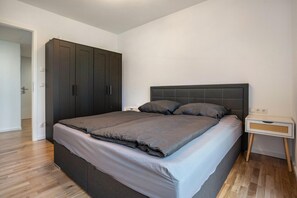 Une chambre à coucher comprenant un lit, une armoire, une table de chevet et une commode.