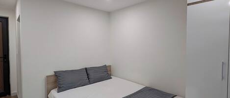 Una camera da letto con un letto, un armadio e una porta.