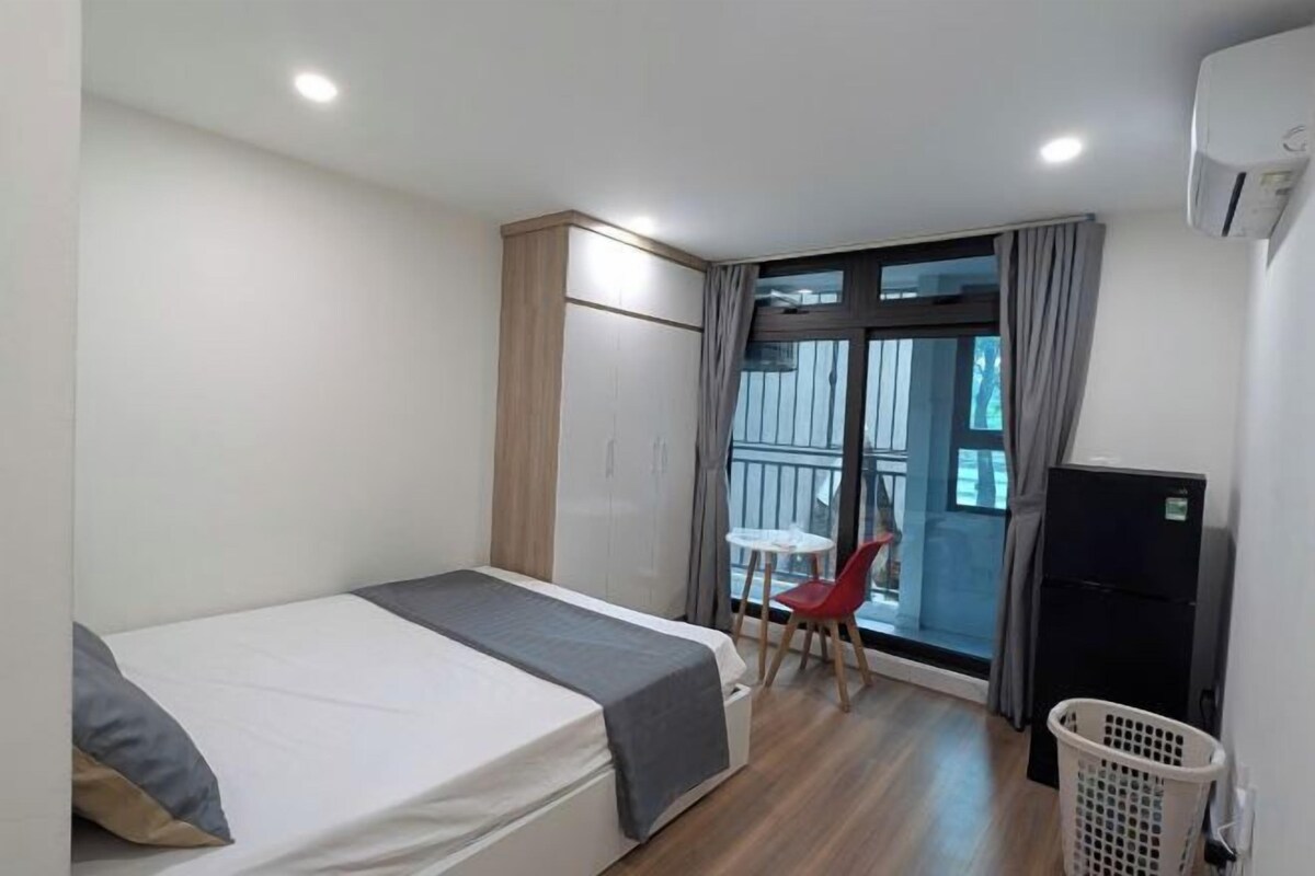 Une chambre d’hôtel avec un lit, une armoire et une petite table avec une chaise.