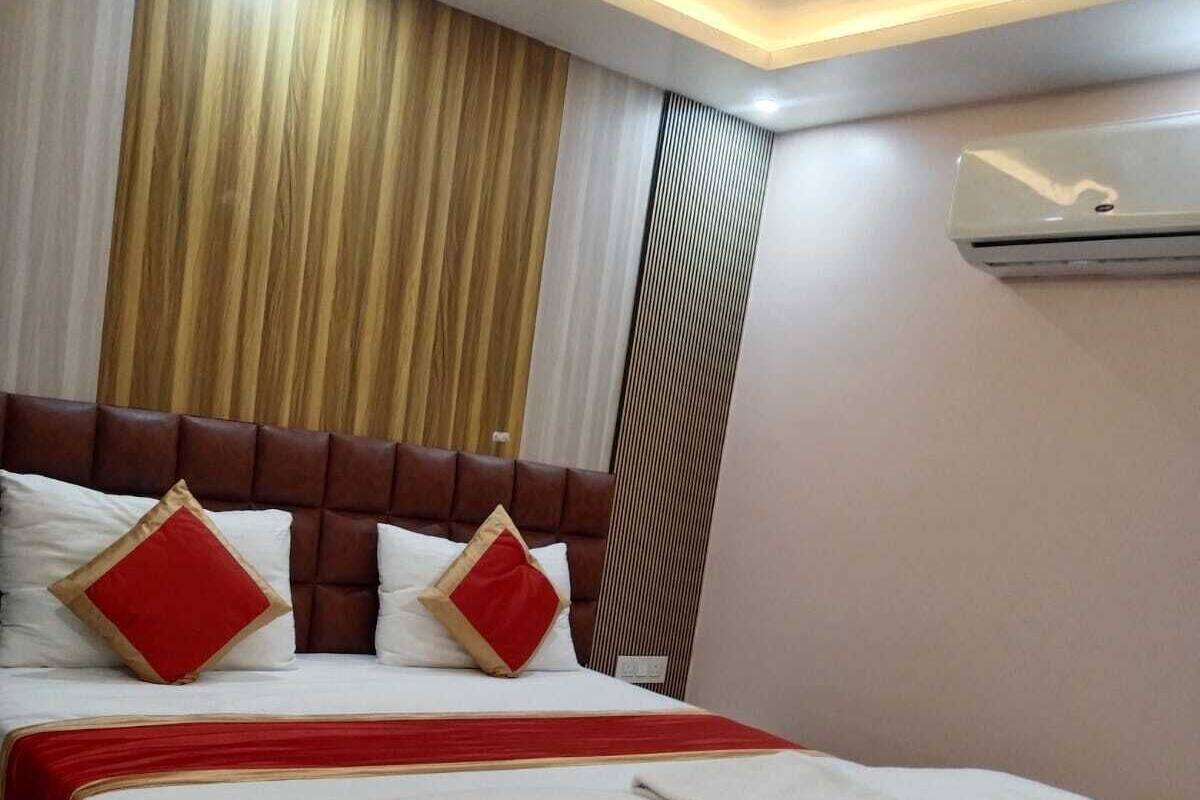 Une chambre d’hôtel dotée d’un grand lit, d’une tête de lit, d’un ventilateur de plafond et d’un appareil de climatisation.