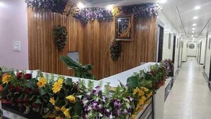 Ein Empfangsbereich mit Holzwand, einer Rezeption und einem Korridor mit Türen.