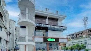 Ein Hotel mit modernem Design, das mit einem markanten Turm und einem Café im Erdgeschoss besticht.