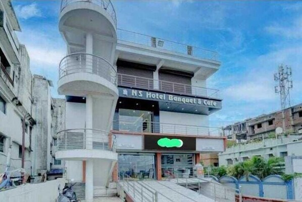 A hotel with a modern design, featuring a prominent tower and a cafe on the ground floor. - N.s Hotel Banquet & Cafe  By GRB (Danapur)