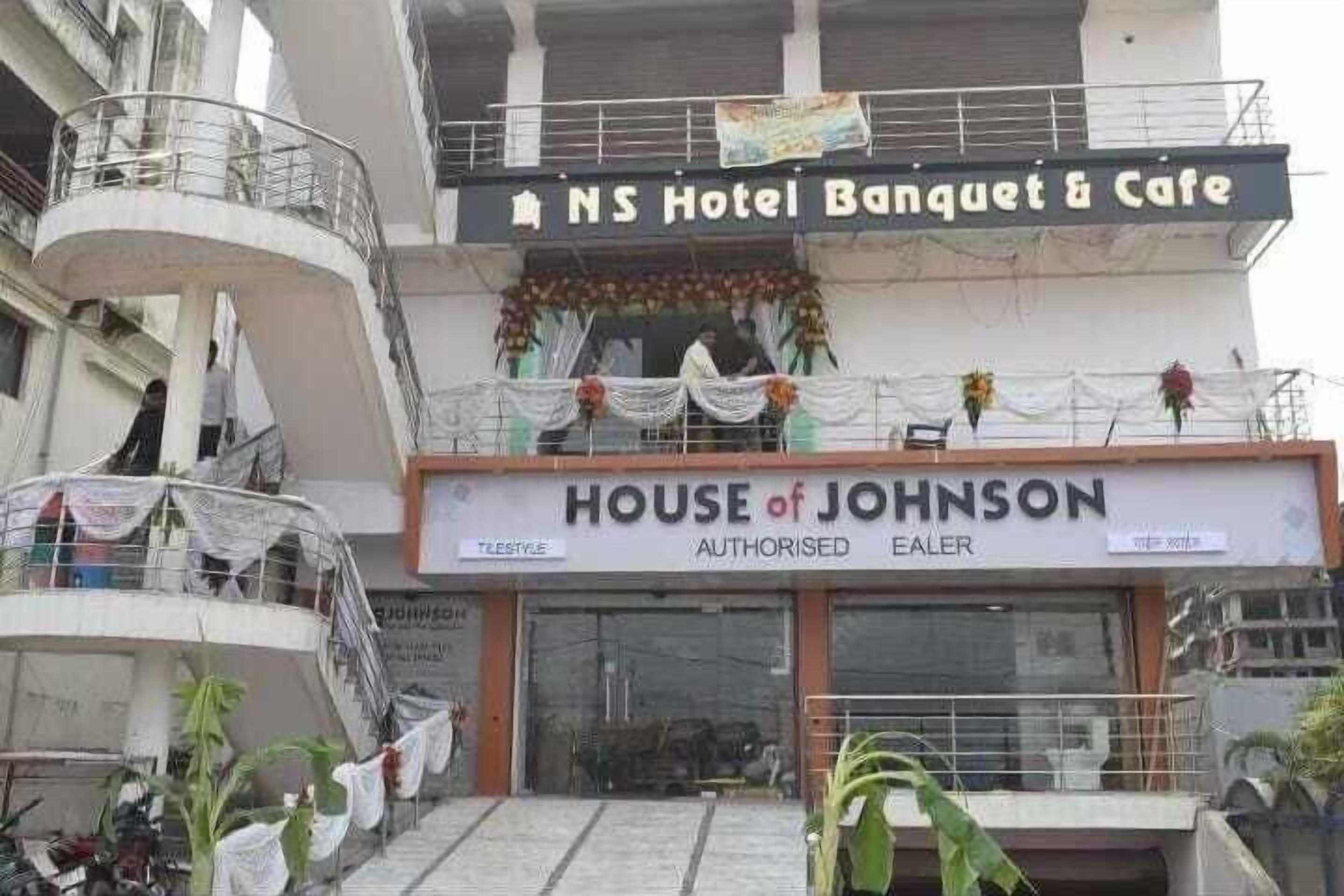 A building with a sign for "NS Hotel Banquet & Cafe" and "House of Johnson" below it.