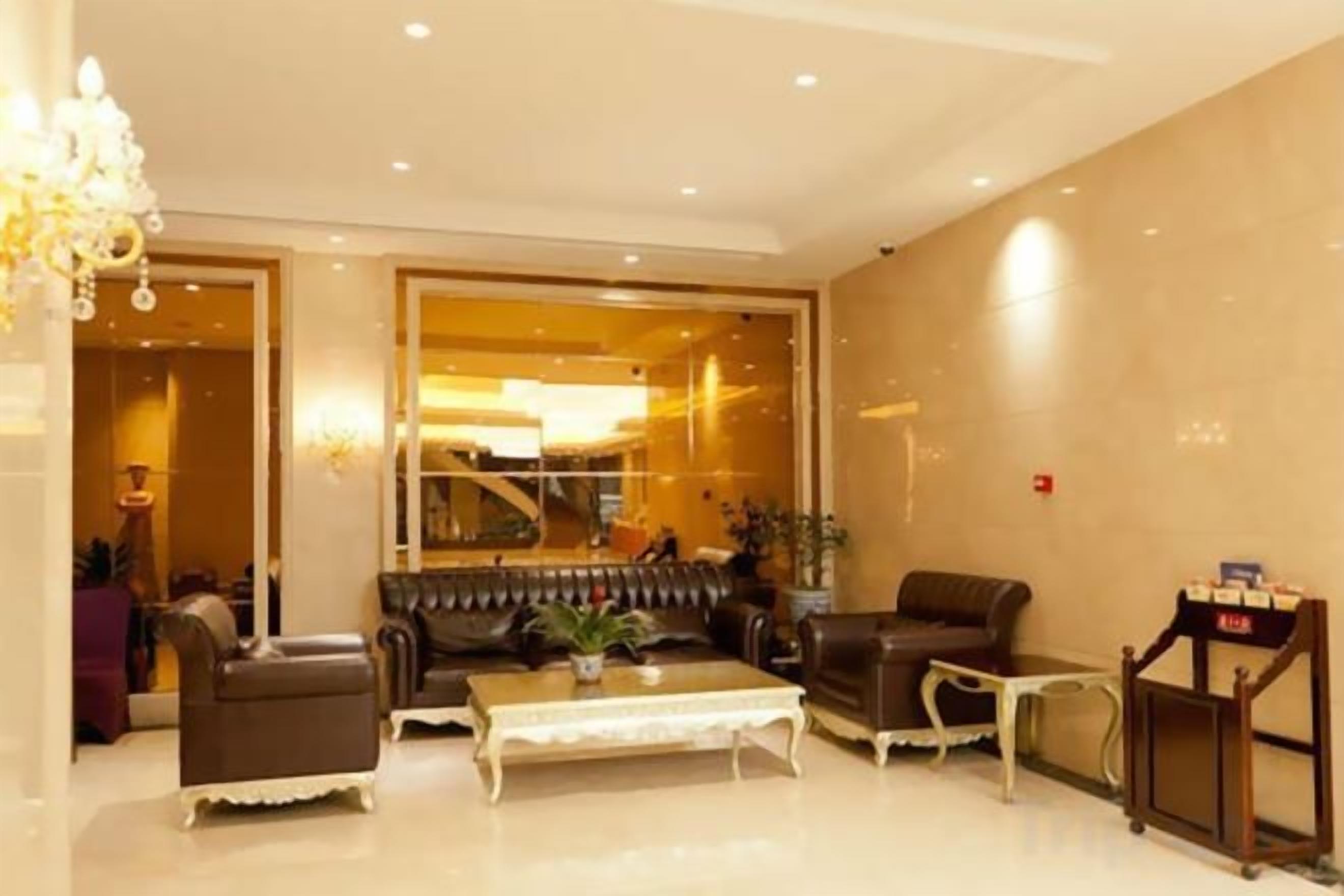 A hotel lobby with a sofa set, a coffee table, and a reception desk.