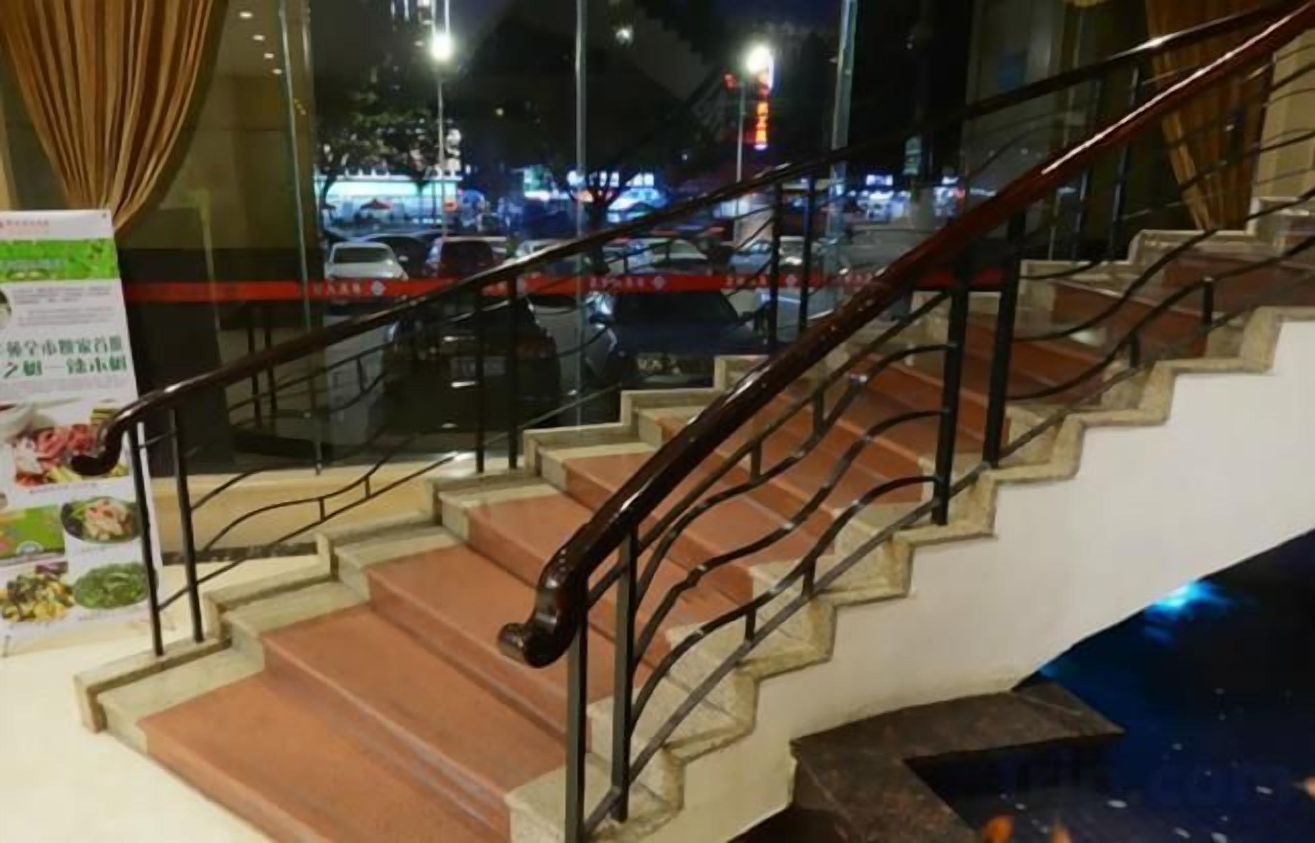A staircase with metal railings and a view of the street outside.