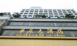 Huayuanda-hotellets exteriör har en modern fasad och hotellets namn syns tydligt.