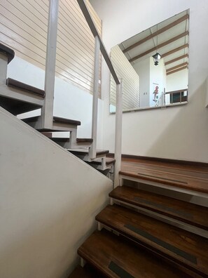 Stairs lead to an upper level, with a large mirror above.