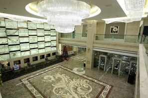 A spacious lobby with a grand chandelier, a large decorative rug, and a high ceiling. - Licheng Youde Hotel (Putian)