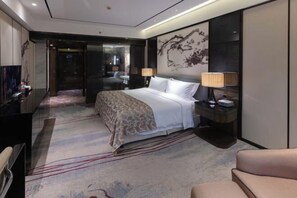 A modern hotel room with a large bed, a desk, a TV, and a painting on the wall. - Licheng Youde Hotel (Putian)