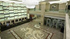 A spacious lobby with a large chandelier, marble flooring, and a glass railing overlooking the lower level. - Licheng Youde Hotel (Putian)