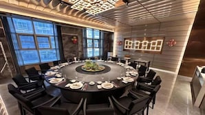 A modern conference room with a round table, black chairs, and a central floral arrangement. - Licheng Youde Hotel (Putian)