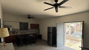 Une cuisine spacieuse avec un coin repas, un réfrigérateur et un ventilateur de plafond.