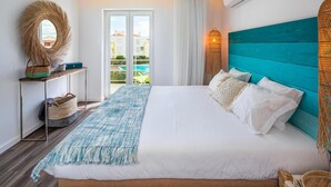 Ein Schlafzimmer mit einem Bett, einem Spiegel, einem Nachttisch, einem Korb und Blick auf einen Pool.