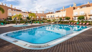 Ein Swimmingpool mit Liegestühlen und einer Holzterrasse.