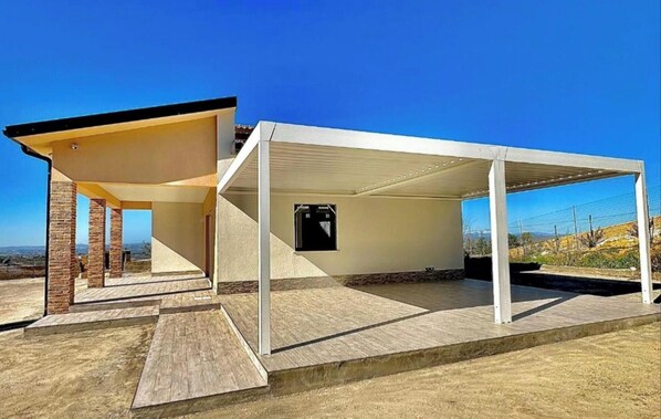 A covered outdoor area with a view of the landscape.