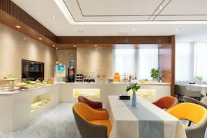 A modern dining area with a buffet, seating, and a view of the kitchen.