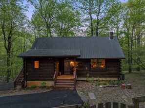 Eine Blockhütte mit Veranda und einer Treppe zum Eingang.
