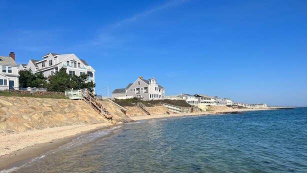 A coastal residential area with houses along the beach, clear blue sky, and calm sea. - ONE Minute walk to BEACH! High end home special! TOP RATED GUEST FAVORITE (Dennis)
