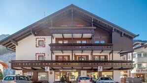 A multi-story building with a traditional Alpine architectural style, featuring balconies and a sign for 'IPB CASSA'. - Apartment 'Appartamento 2-3 Persone' with Mountain View, Balcony and Wi-Fi (Canazei)