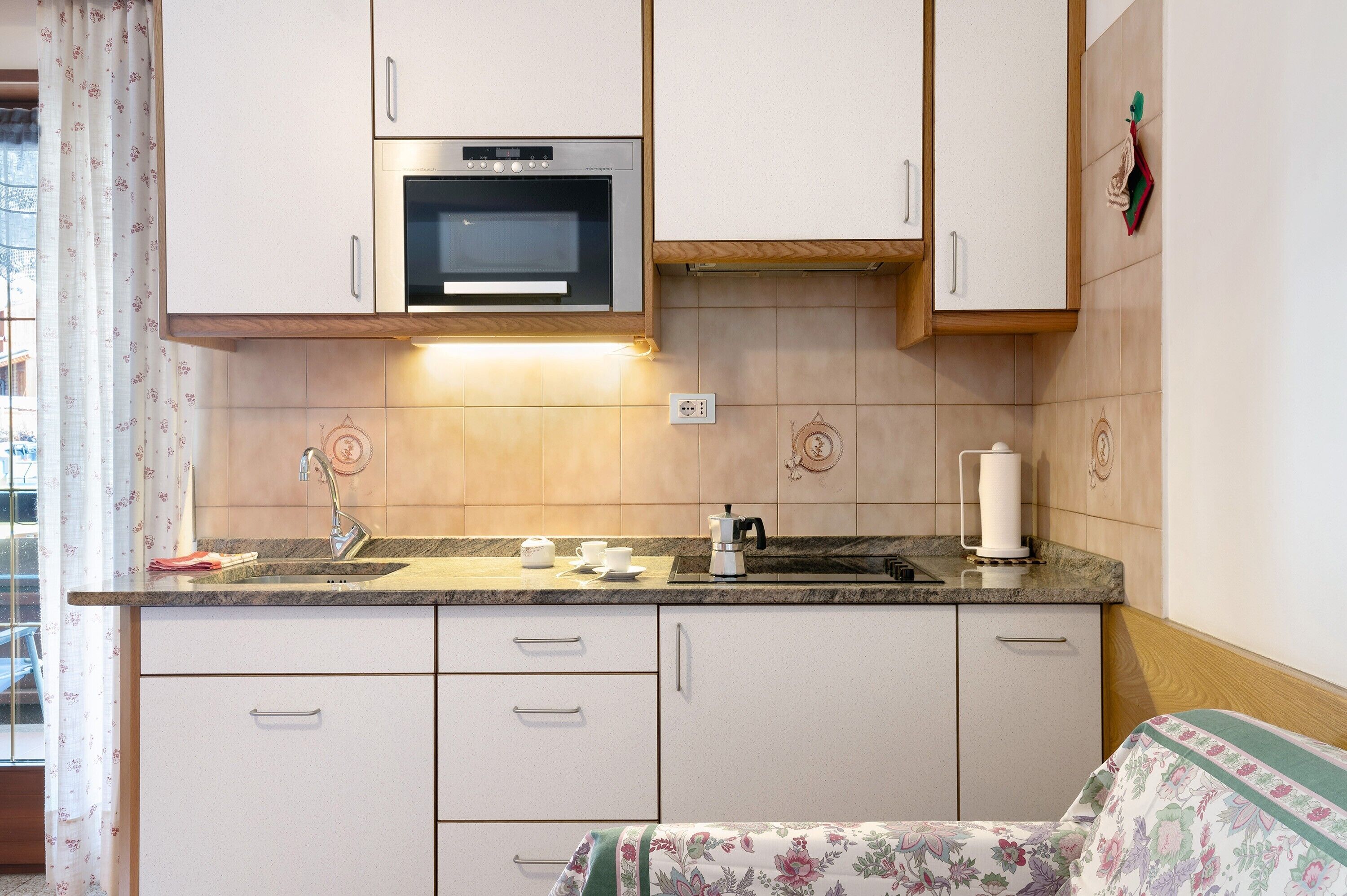 A kitchen with a microwave, sink, and cabinets.