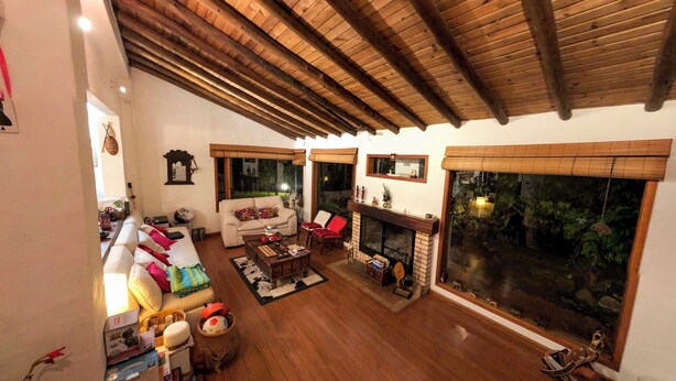 A spacious living room with a wooden ceiling, a fireplace, and large windows. - 3-room beautiful cottage close to Laguna Guatavita (Cundinamarca)