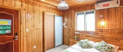 Um quarto com painéis de madeira, uma cama, uma porta e uma janela.